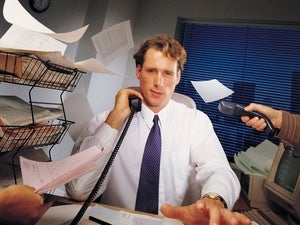 Efficiency - a busy man at his desk, surrounded by chaotic paperwork